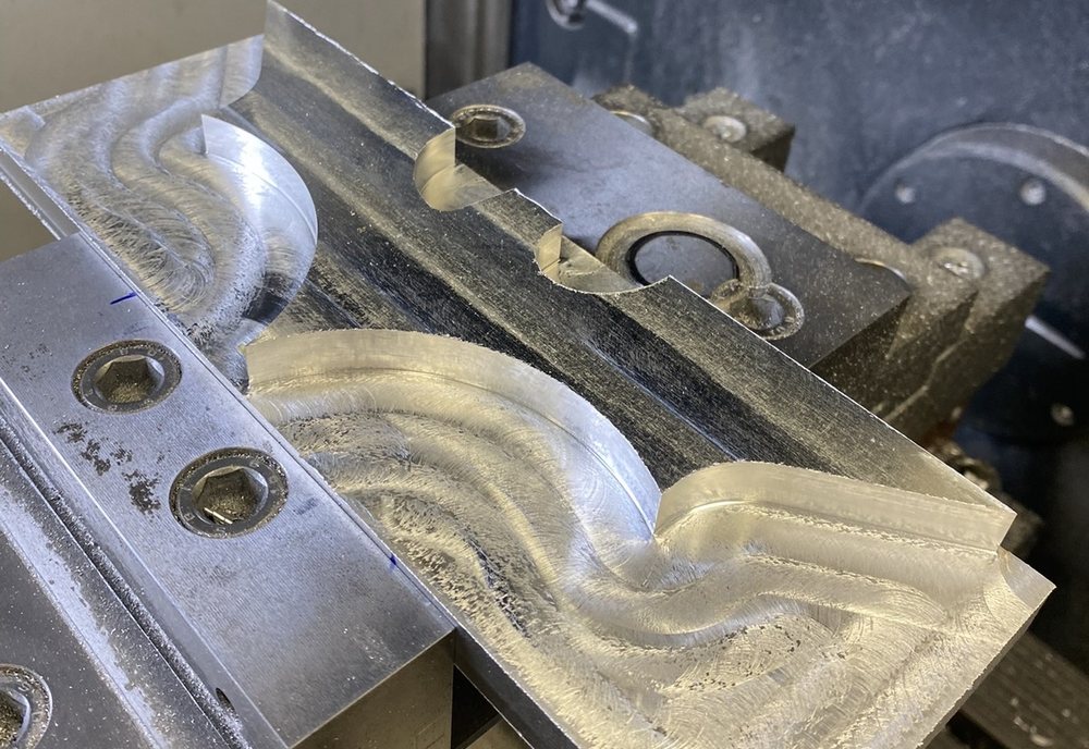 Aluminiumplatte mit gefrästem Emblem im Spannstock der CNC-Fräsmaschine